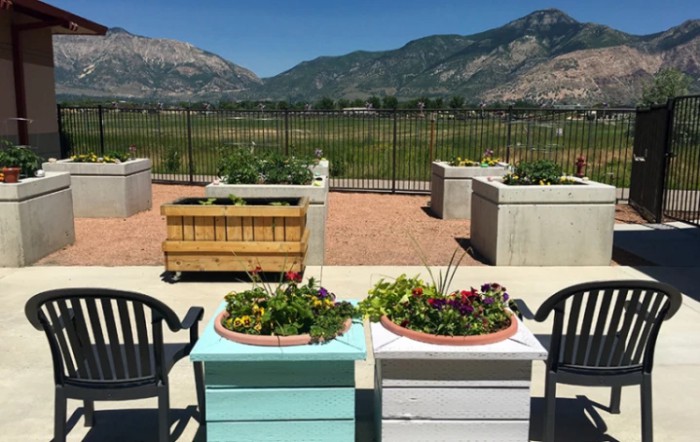 A scenic garden with planters and chairs overlooking a mountain view.