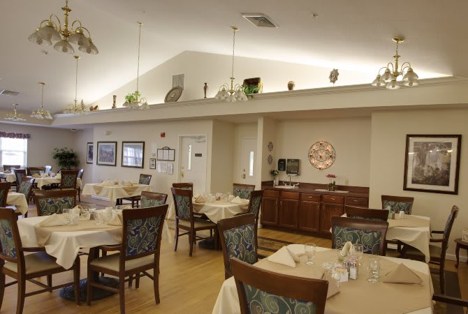 A cozy dining area with neatly arranged tables and chairs, featuring elegant decor.