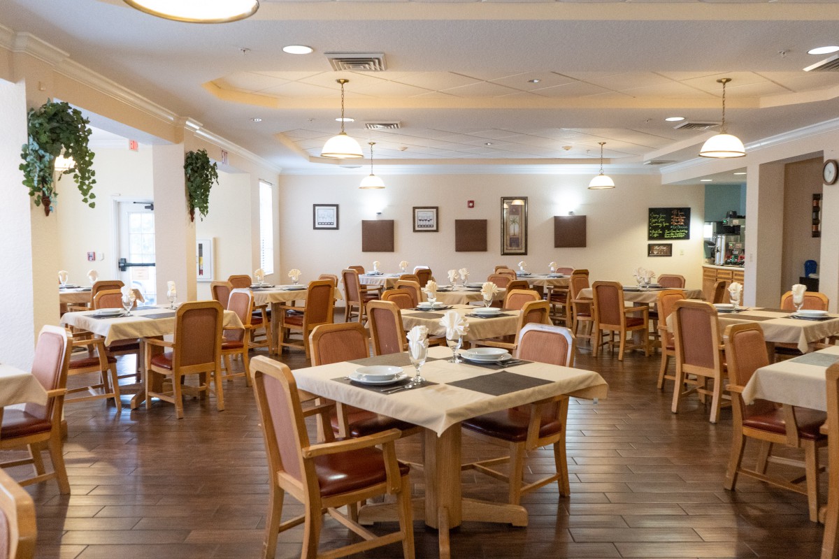 A well-lit dining area with neatly arranged tables and chairs.