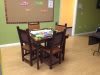 A classroom setting with a table and chairs arranged around it.