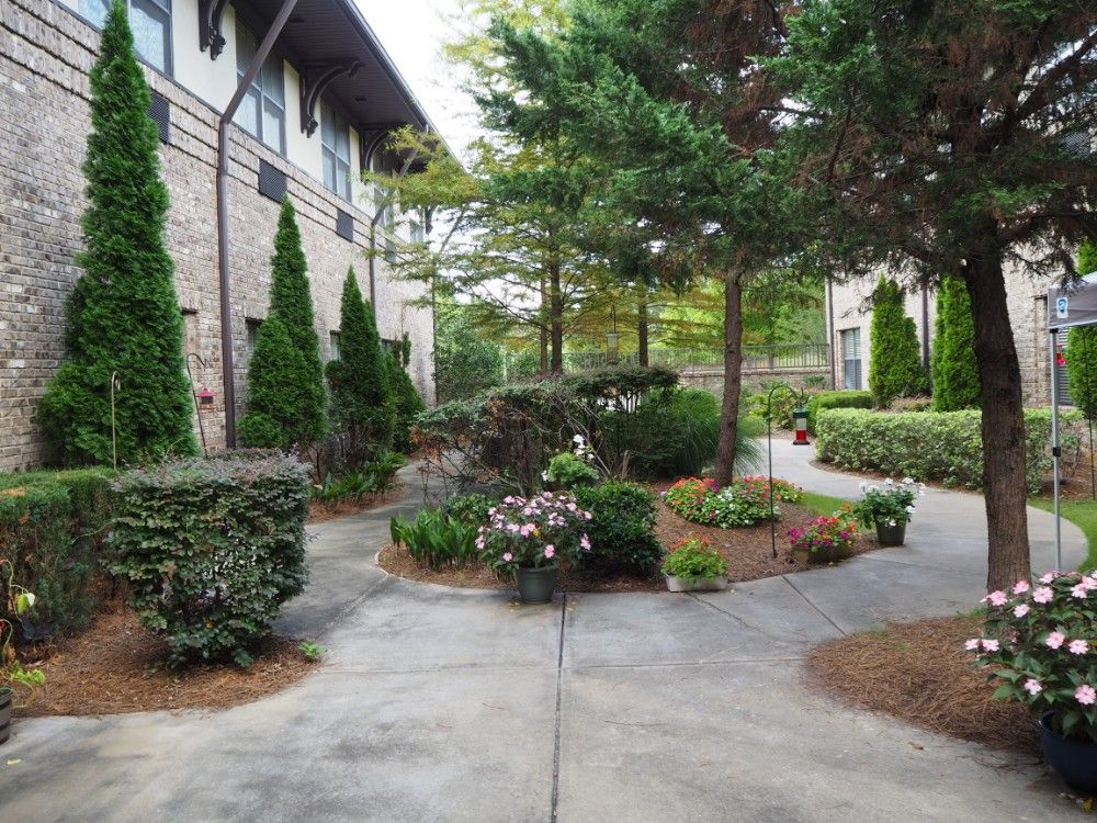 A well-maintained garden path surrounded by greenery and shrubs.