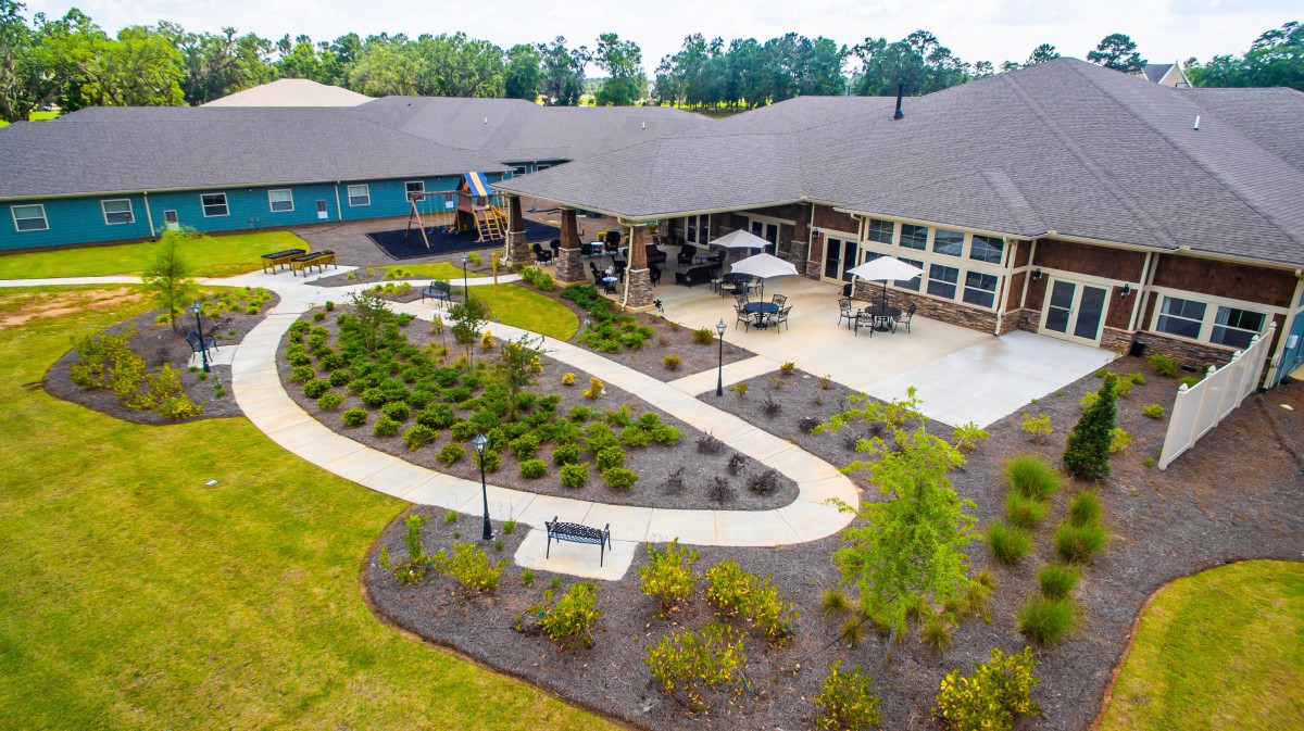Aerial view of a building with a landscaped garden and winding pathways.