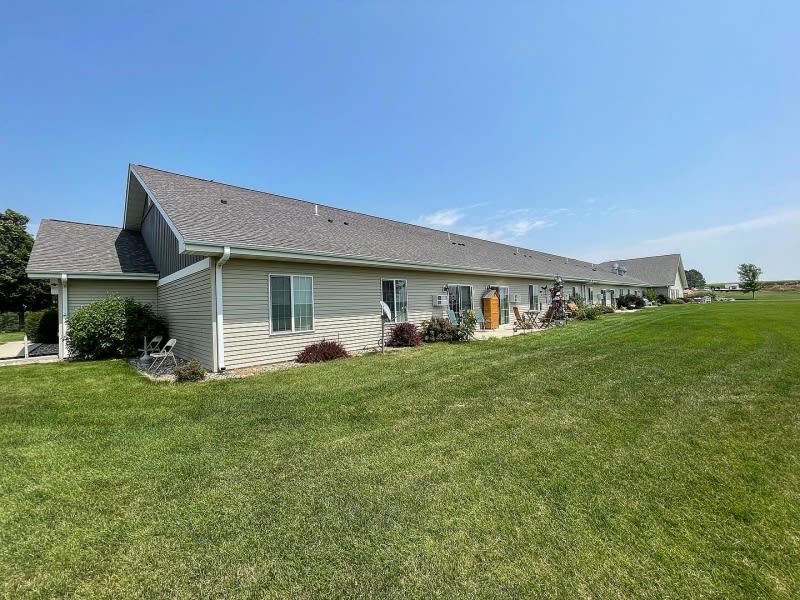 A row of residential homes with a well-maintained lawn under a clear blue sky.