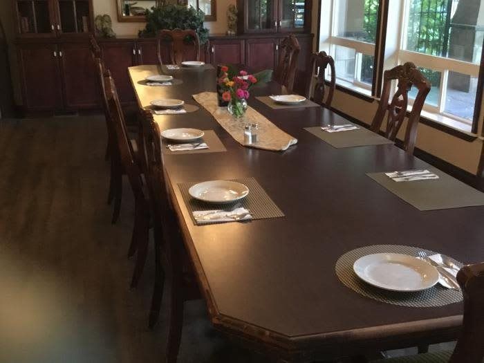 A dining room with a long table set for a meal.