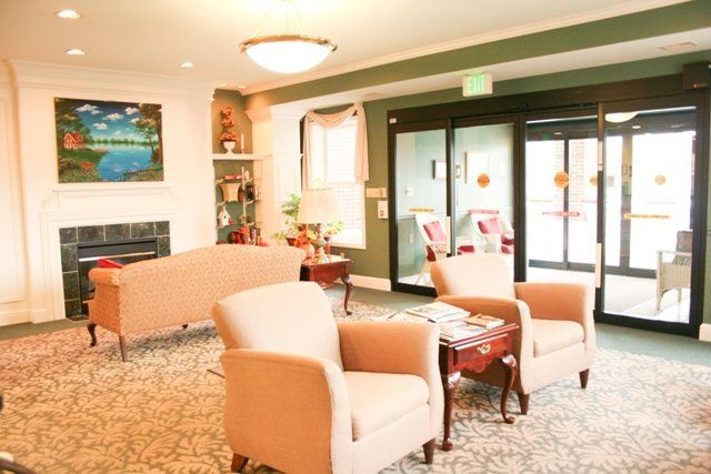 A cozy lobby area with comfortable chairs and a small table, featuring warm lighting and decorative elements.