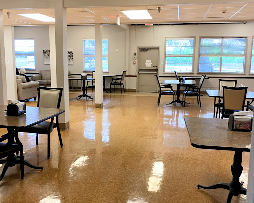 A spacious and bright dining area with tables and chairs arranged for use.