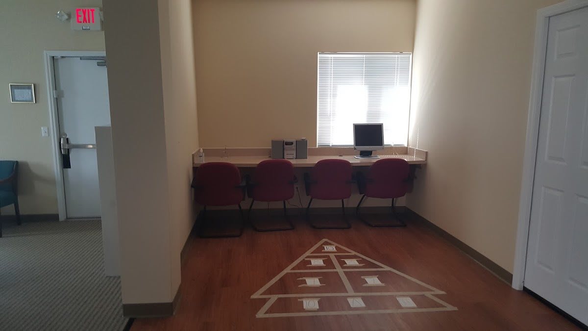 A minimalist workspace with computers and chairs in a well-lit room.