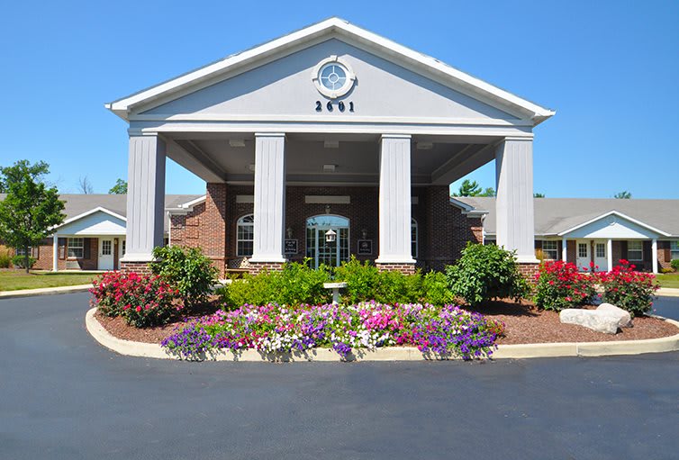 An inviting building entrance with columns and a landscaped garden.