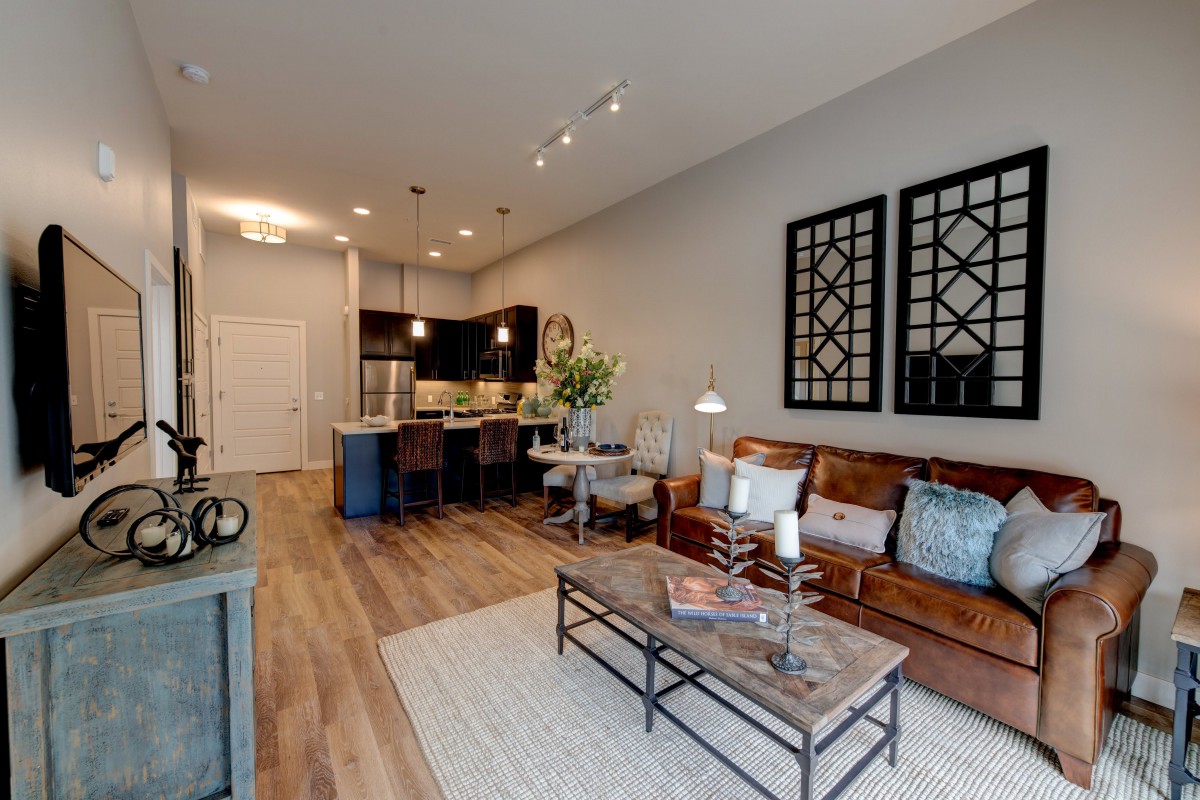 A modern open floor plan living room and kitchen area with stylish furniture and decor.