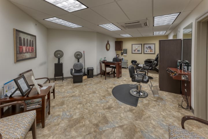 A modern hair salon with styling stations and a waiting area.