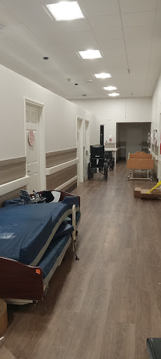 A hallway in a hospital featuring medical beds and equipment.