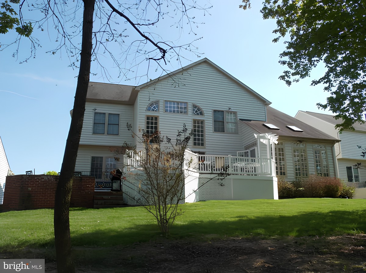 A suburban house with a large yard, captured on a sunny day.