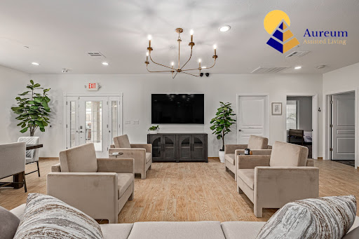 A modern living room featuring comfortable seating, a stylish chandelier, and a large television.