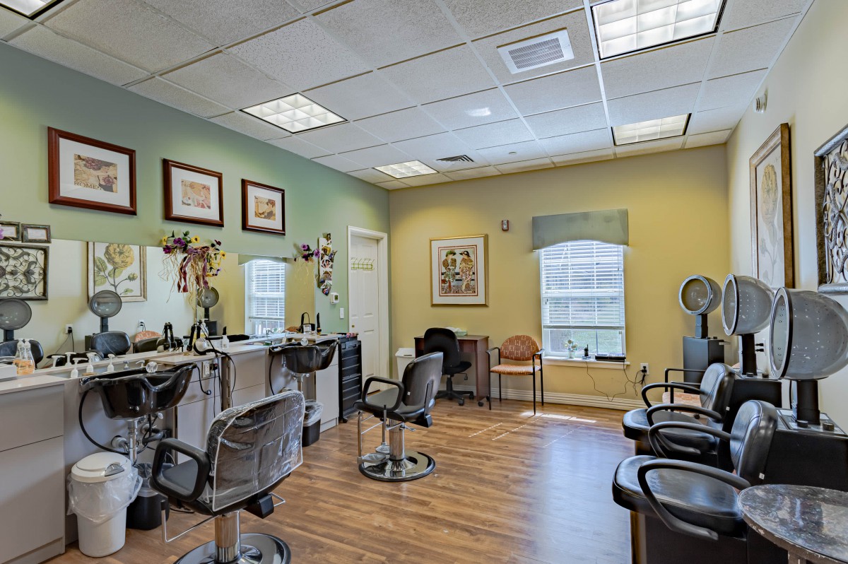 A well-lit hair salon with several chairs and mirrors arranged neatly in a cozy setting.
