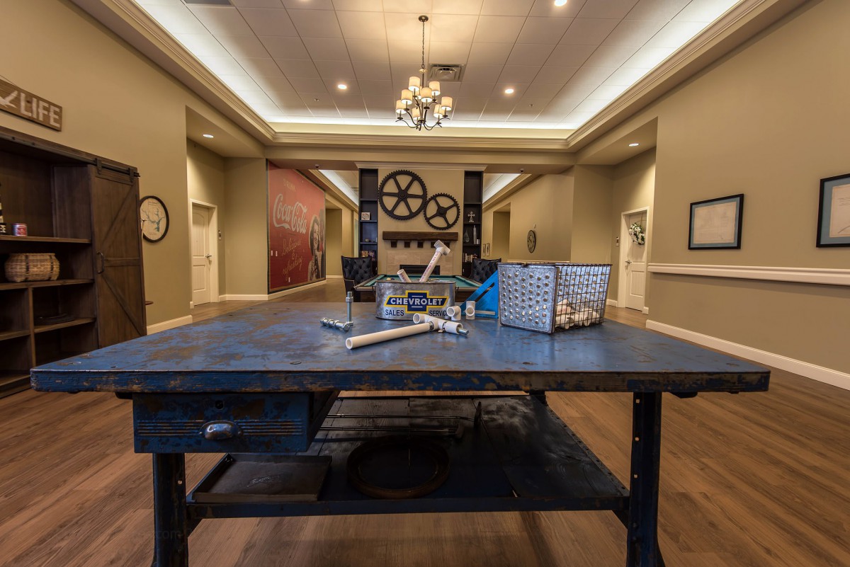 An industrial-style room featuring a central work table with gears and mechanical decor.
