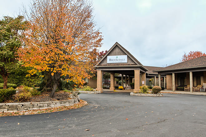 A building with an entrance surrounded by autumn trees.