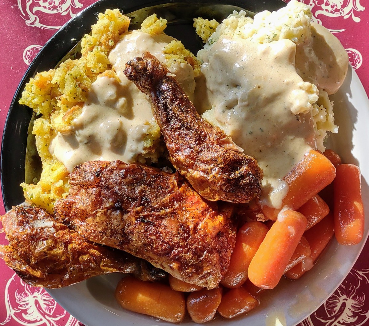 A hearty plate featuring fried chicken, mashed potatoes with gravy, stuffing, and carrots.