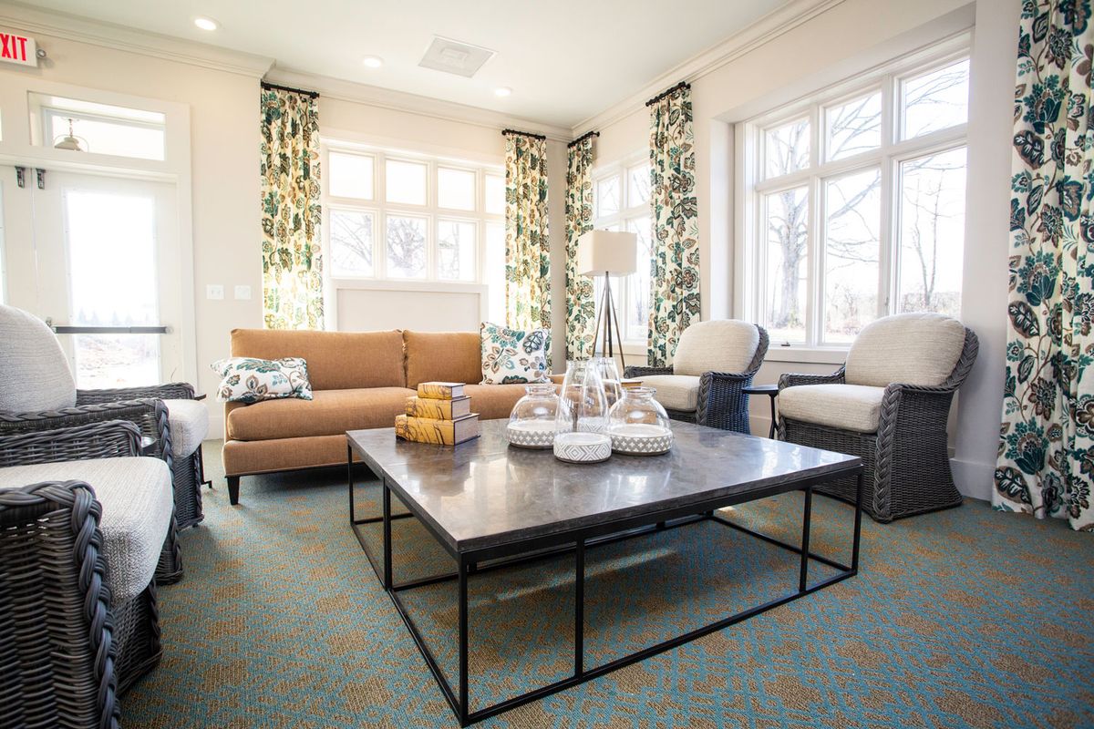 A cozy living room with contemporary furniture and large windows.