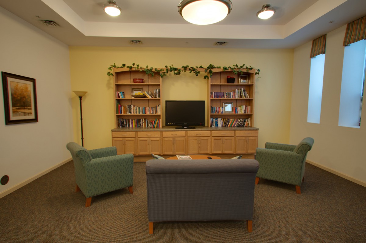 A cozy living room with bookshelves, a TV, and comfortable seating.
