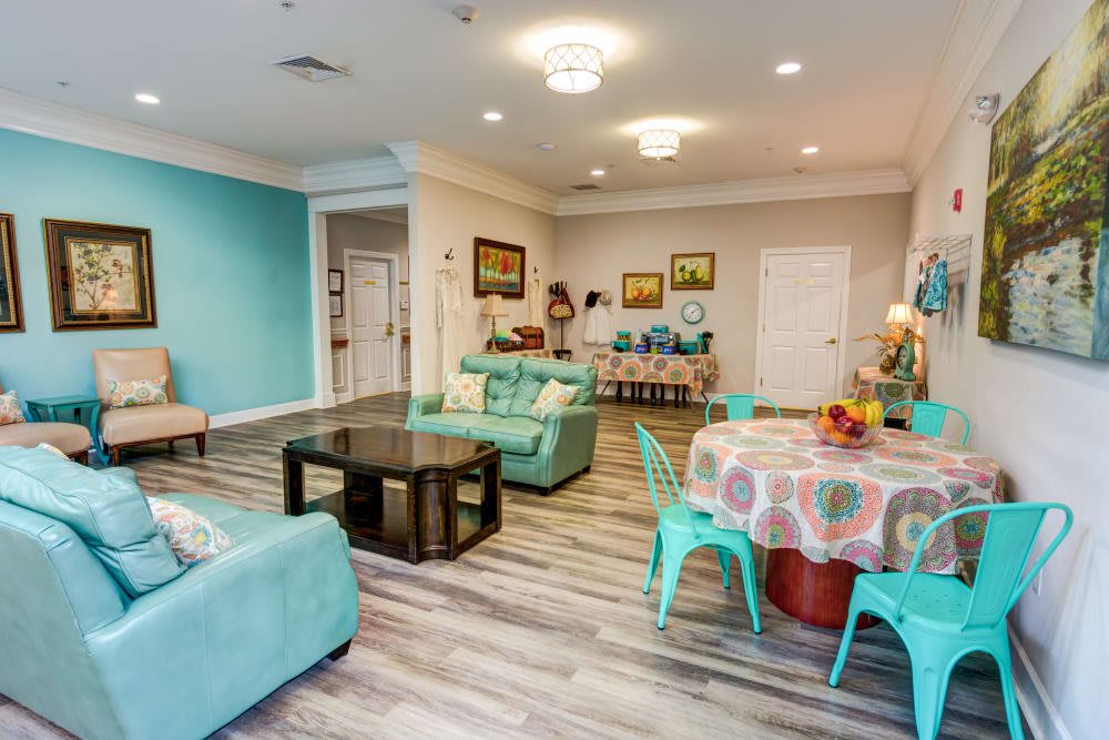 A modern living room with teal accents and colorful furniture, creating a cozy and inviting atmosphere.