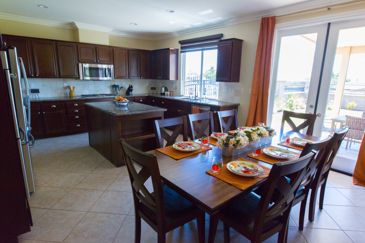 A modern kitchen and dining area with wooden furniture and ample natural light.
