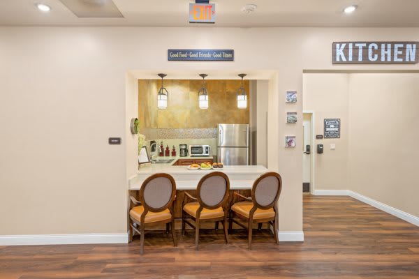 A modern kitchen interior with a seating area featuring three chairs at the counter.