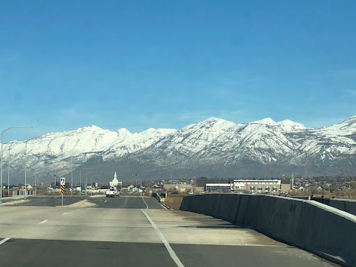 A scenic drive with snow-capped mountains under a clear blue sky.