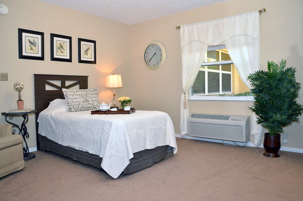 A cozy and neatly decorated bedroom with a bed, lamp, and window.