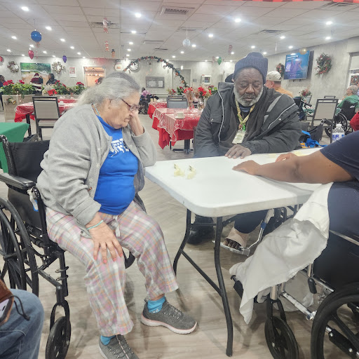 Elderly individuals engaged in a social game at a communal activity space.