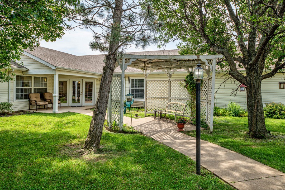 A cozy backyard with a pergola and well-maintained lawn.