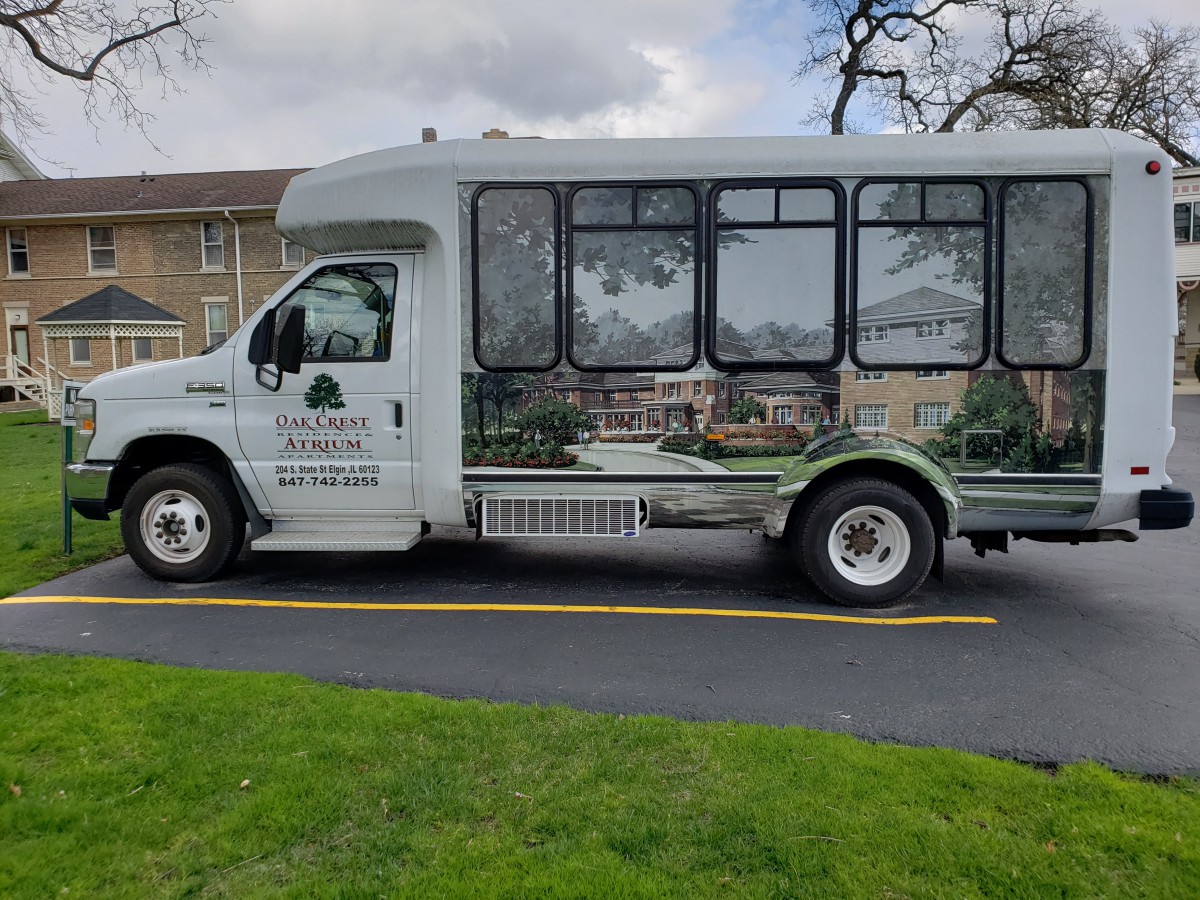 A shuttle bus parked on the side of a road on a cloudy day.