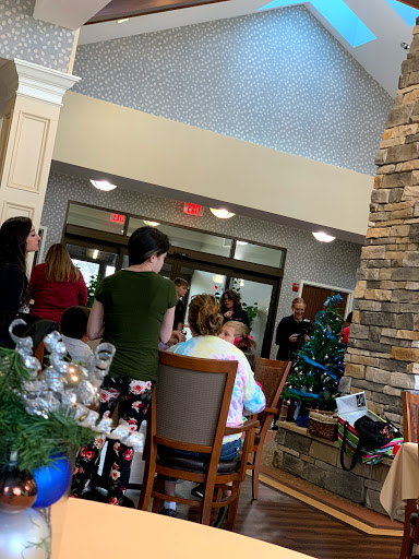 A festive gathering during the holiday season, featuring a decorated Christmas tree and cheerful attendees.