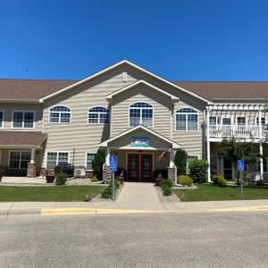 Front view of a residential building with well-maintained landscaping under a clear blue sky.