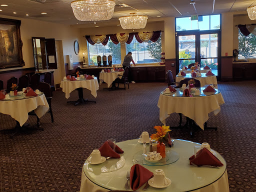 A beautifully arranged dining area in a restaurant, featuring elegant tables and chandeliers.