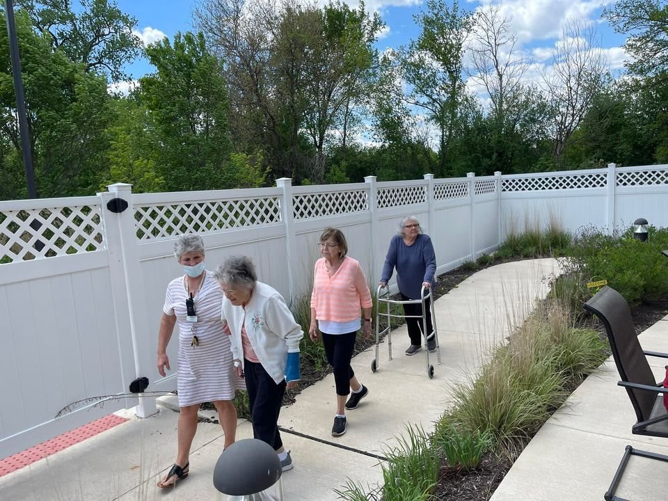 A group of seniors enjoying a walk outdoors on a sunny day.
