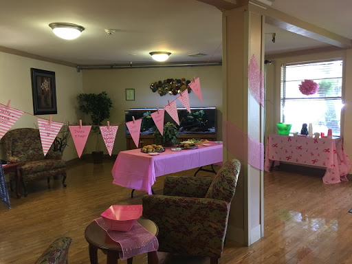A brightly decorated room ready for a special celebration with pink banners and festive decor.