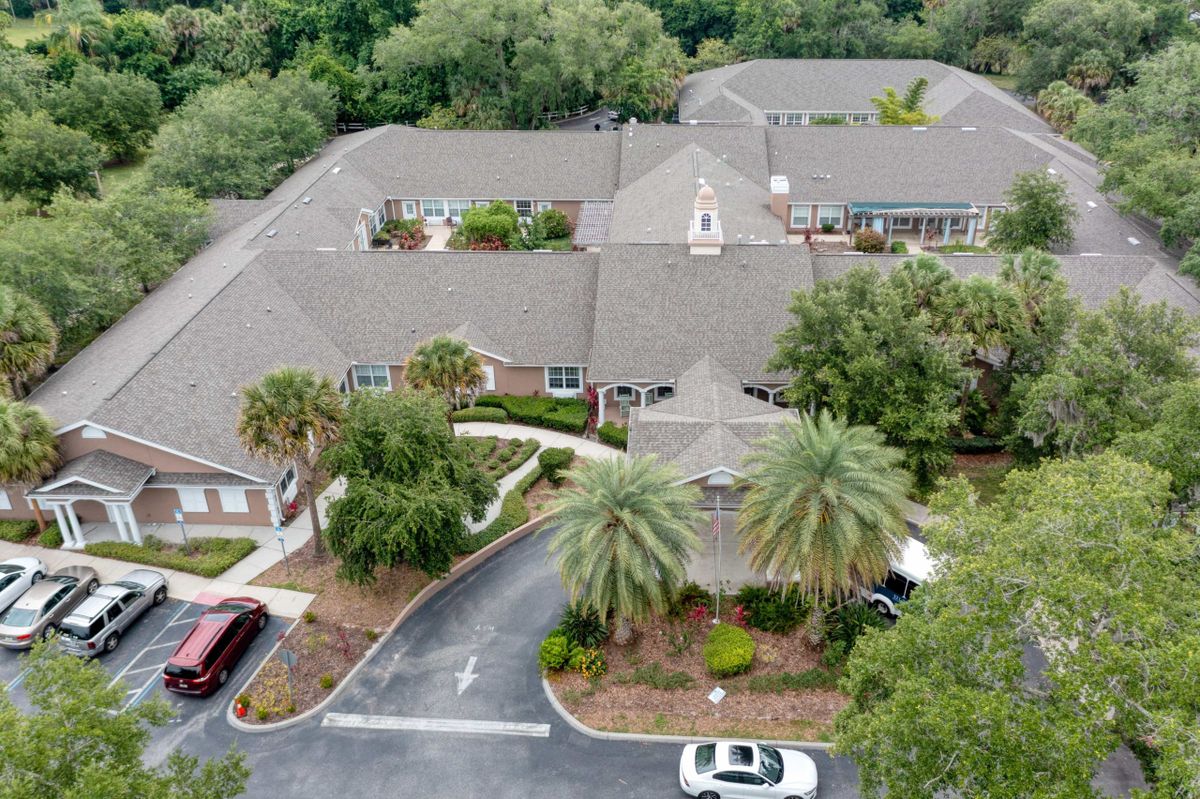 Aerial view of a residential building complex surrounded by trees and greenery.