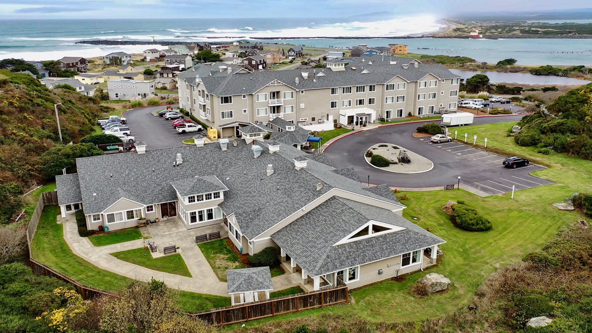 An aerial view of a coastal community featuring large residential buildings near the ocean.