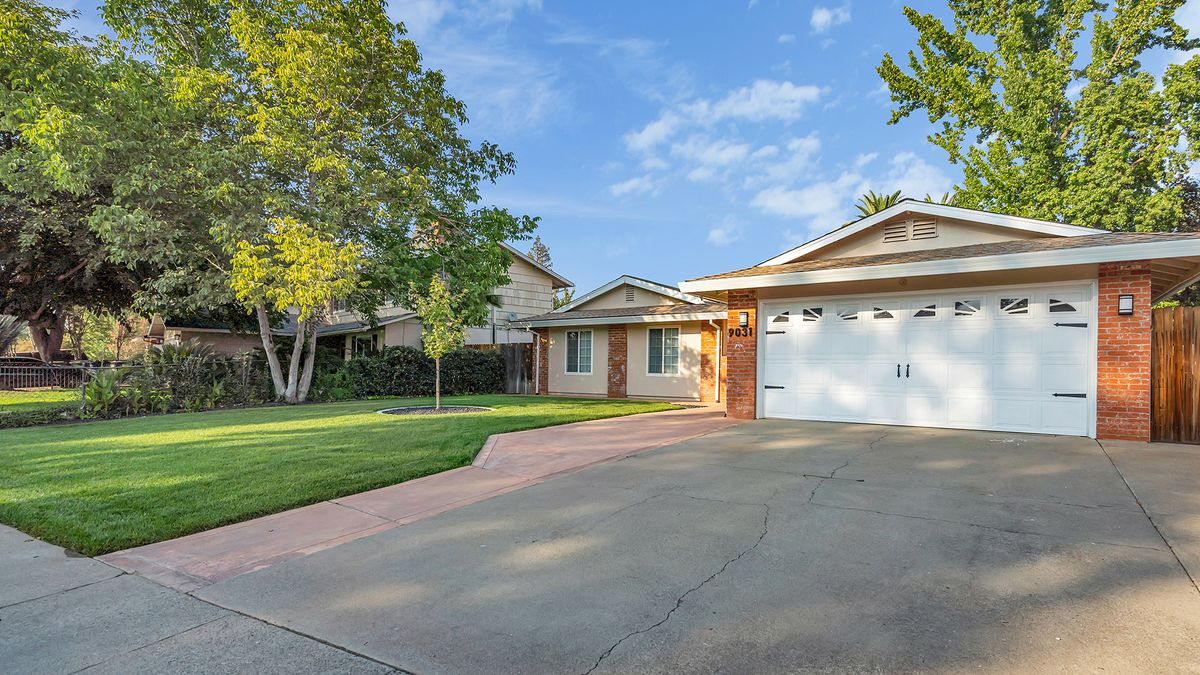 A suburban house with a driveway and well-maintained lawn.