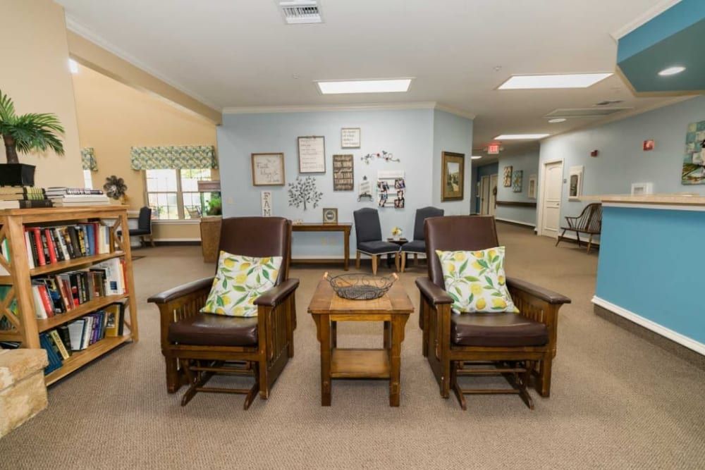 A cozy lobby seating area with two cushioned chairs and a small wooden table.