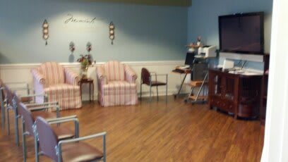 A cozy waiting room with various chairs, a television, and decorative elements.