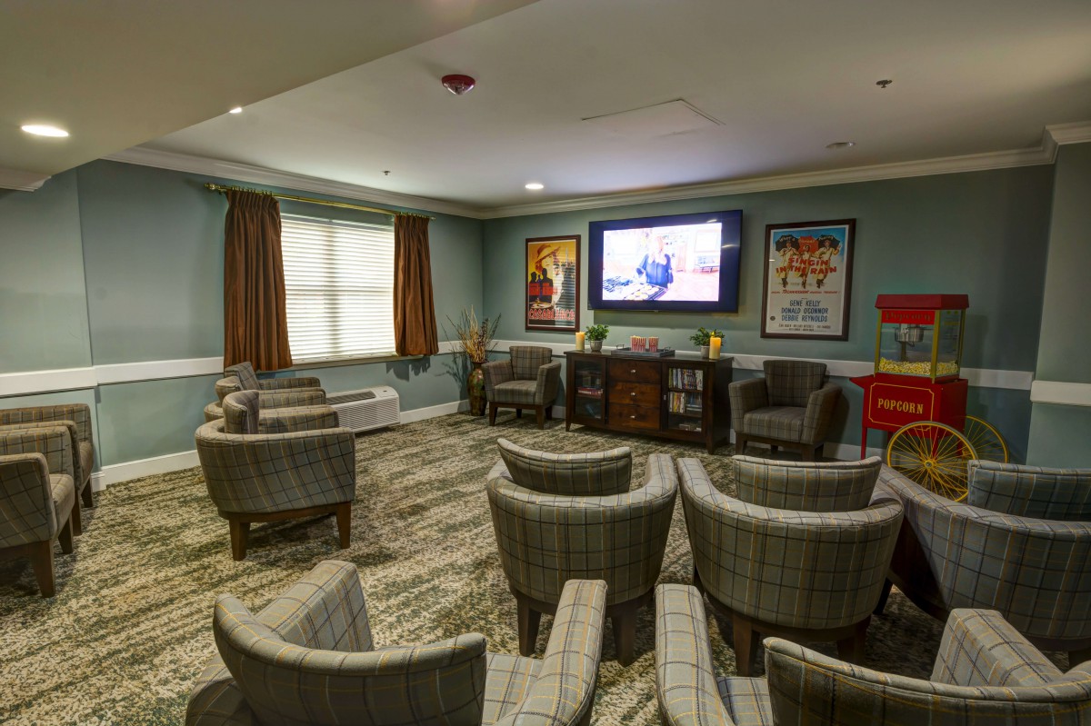 A cozy theater room with comfortable seating and movie posters on the walls.