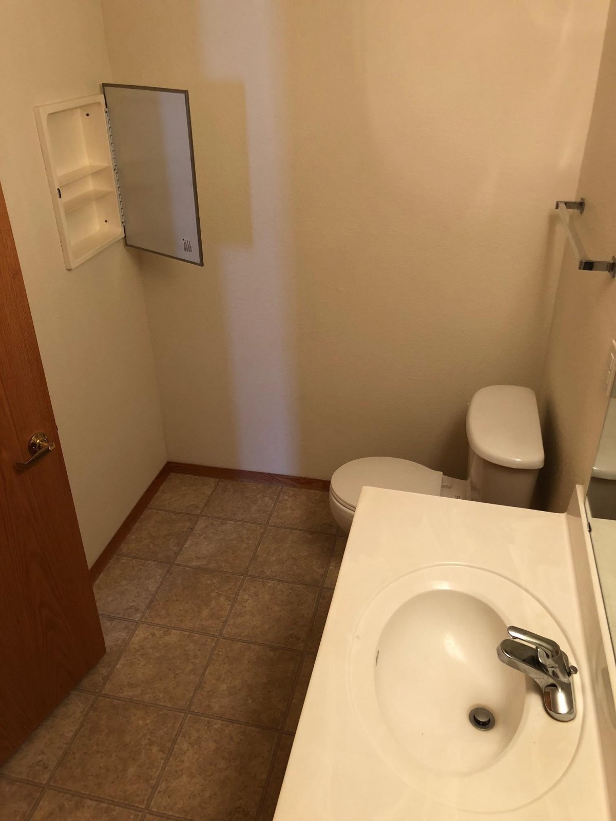 A small bathroom with a sink, toilet, and mirror.