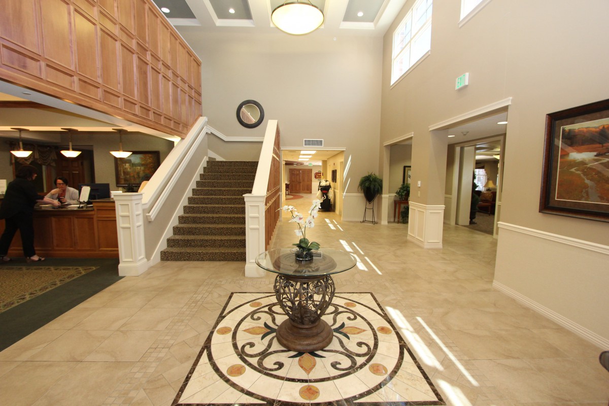 A spacious and elegantly designed lobby with a central decorative table and staircase.