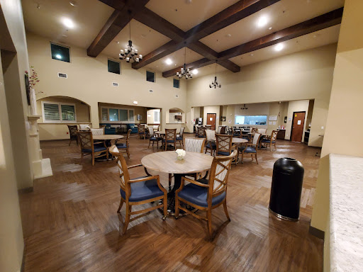 A spacious and cozy dining area featuring elegant wooden furniture and chandeliers.