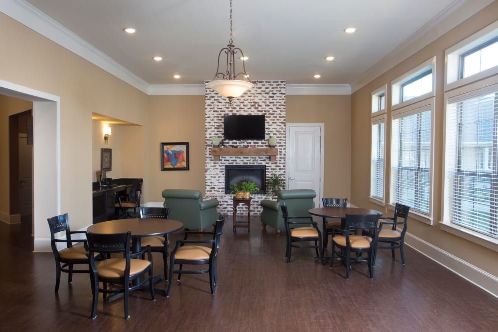 A modern community room with a fireplace, television, and seating area.