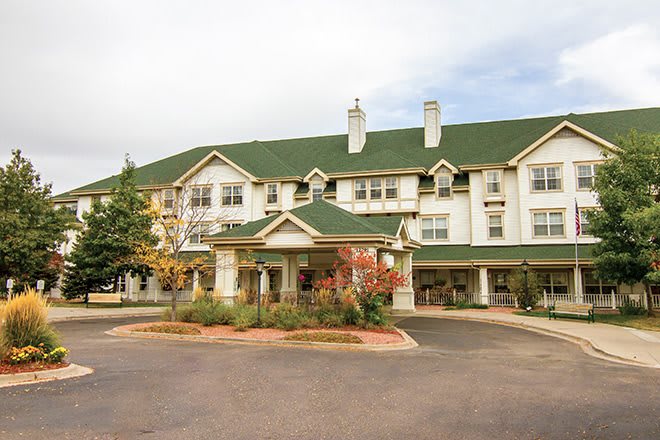 A large residential building with a green roof and landscaped surroundings.
