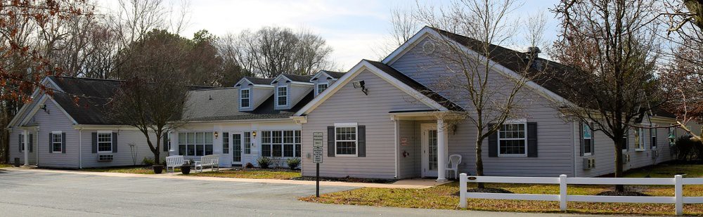 A suburban residential house with multiple dormers and a well-maintained exterior.