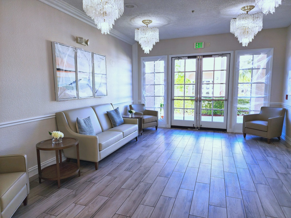 A bright and inviting waiting room with elegant chandeliers, comfortable seating, and tasteful decor.