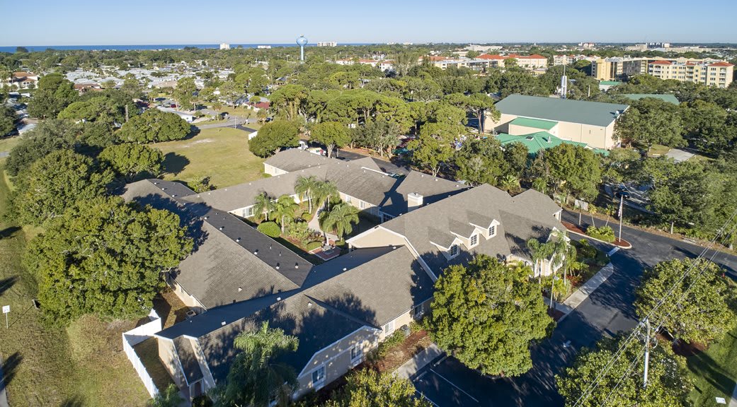 Aerial view of suburban buildings surrounded by lush greenery.